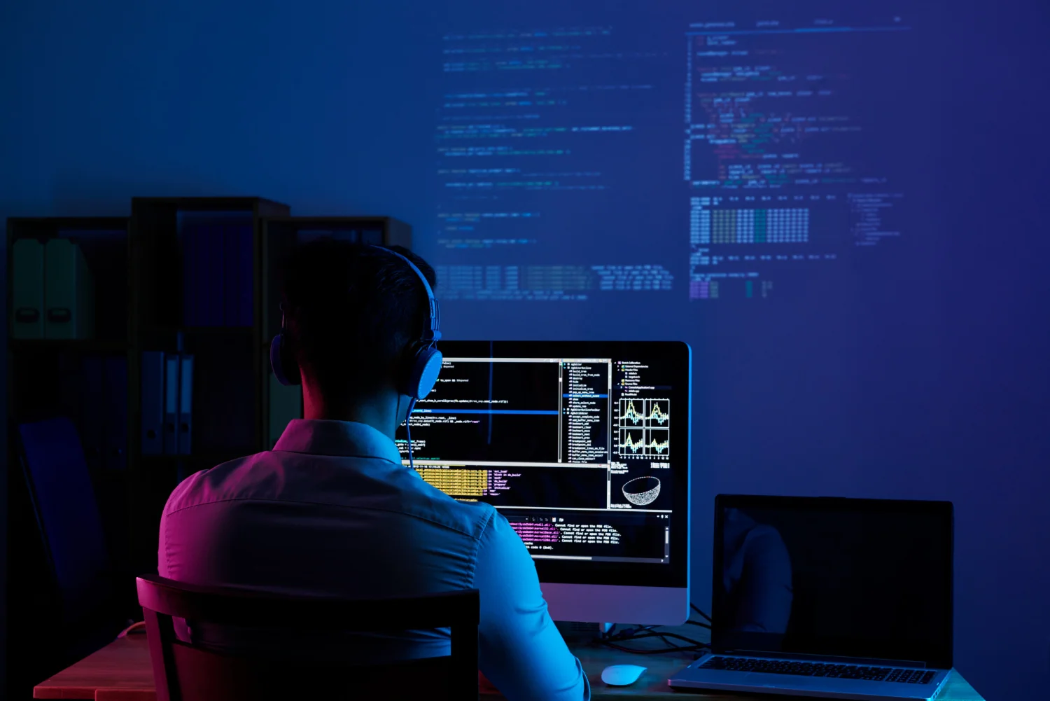 Analista che monitora dashboard di sicurezza e dati di accesso in tempo reale su più schermi